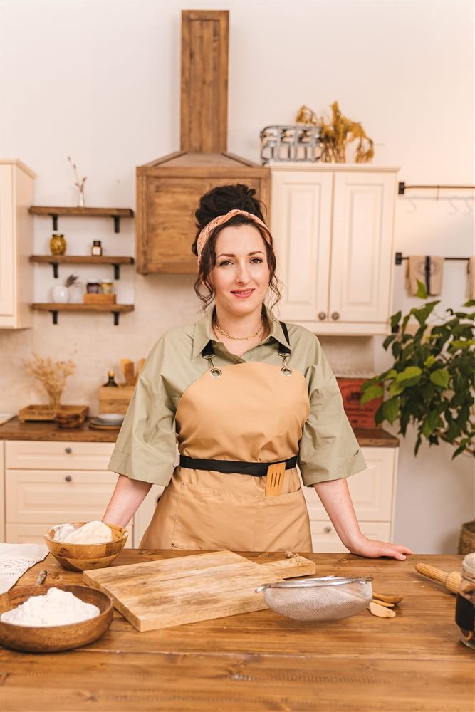Ana, personal chef, sorrindo, em pé na cozinha